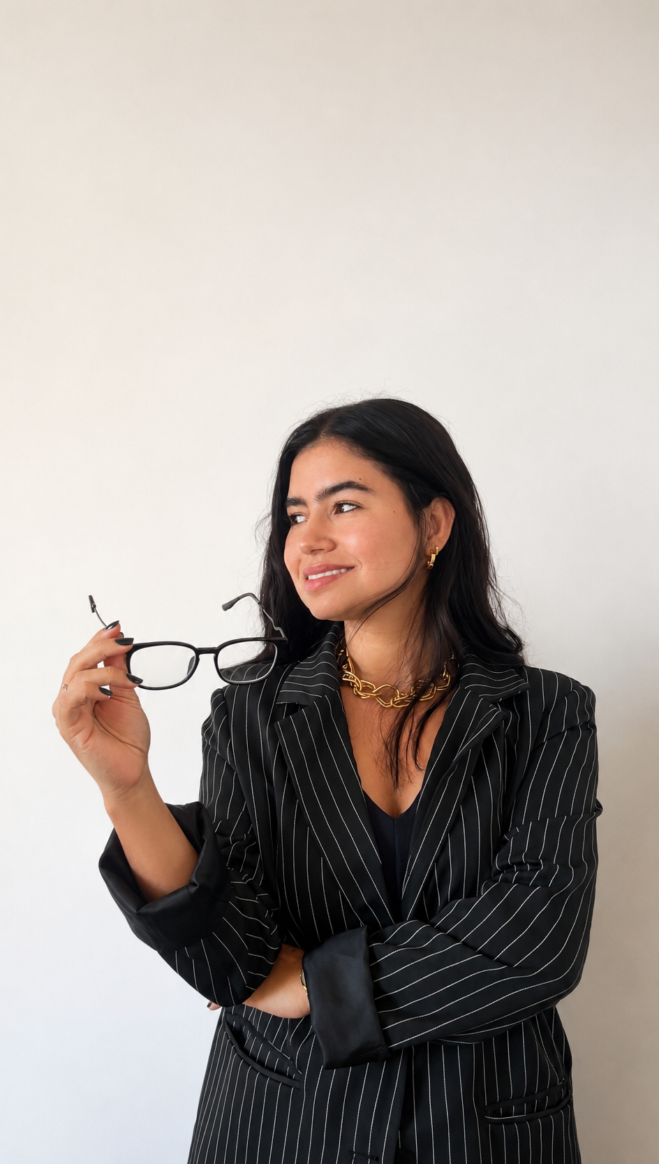 Advogada Francieline Santos usando blazer riscado e segurando os óculos